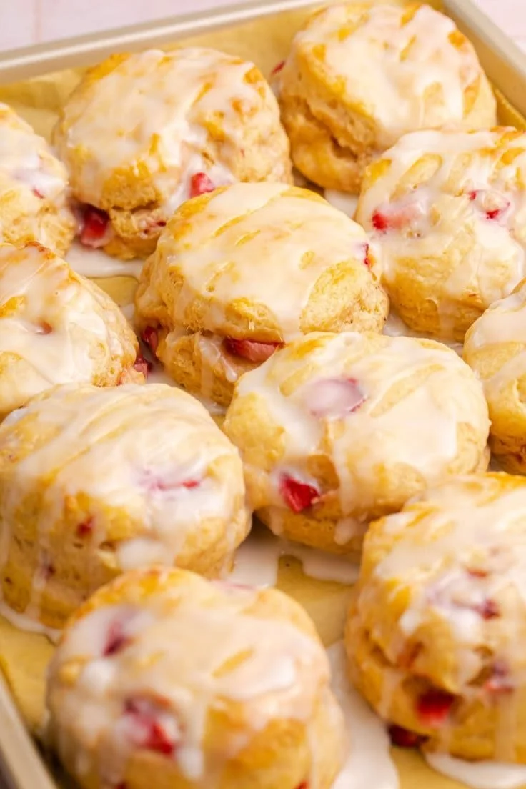 Freshly baked strawberry biscuits on a wooden table.