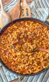A delicious bowl of homemade goulash topped with herbs and served with bread.