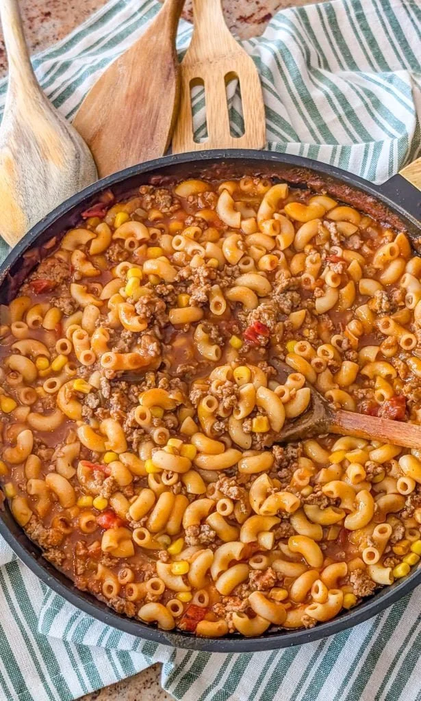 A delicious bowl of homemade goulash topped with herbs and served with bread.