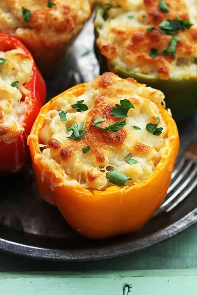Three cheese macaroni stuffed peppers on a plate ready to enjoy