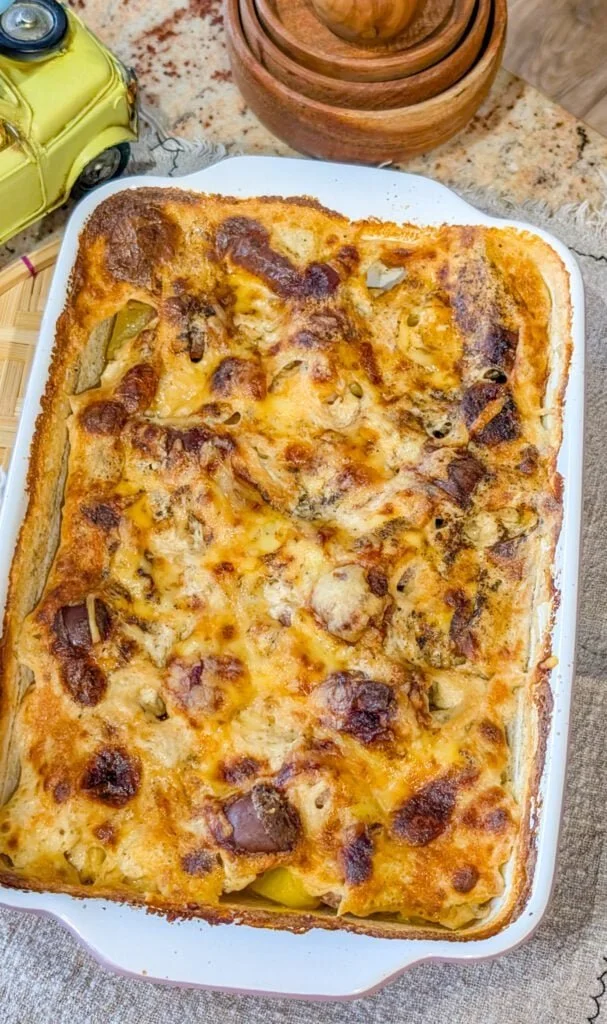 Delicious warm cheesy potato sausage casserole in a baking dish