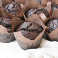 Freshly baked bakery style double chocolate chip muffins with chocolate chips.