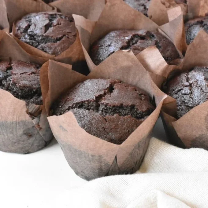Freshly baked bakery style double chocolate chip muffins with chocolate chips.
