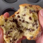 Fluffy chocolate chip muffins with melted chocolate chips on top.