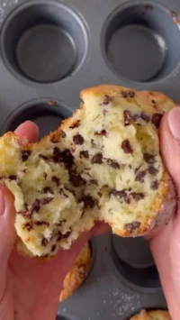Fluffy chocolate chip muffins with melted chocolate chips on top.