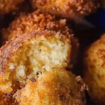 Homemade hush puppies frying in a skillet, golden and crispy