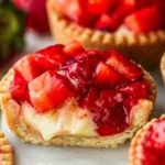 Mini strawberry tartlets topped with fresh strawberries and creamy filling.