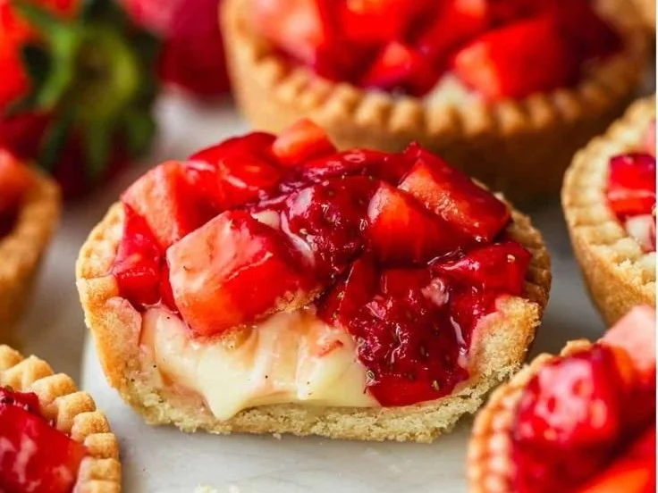 Mini strawberry tartlets topped with fresh strawberries and creamy filling.