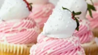 Delicious white chocolate covered strawberry cupcakes on a plate
