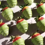 White chocolate matcha-covered strawberries arranged on a plate