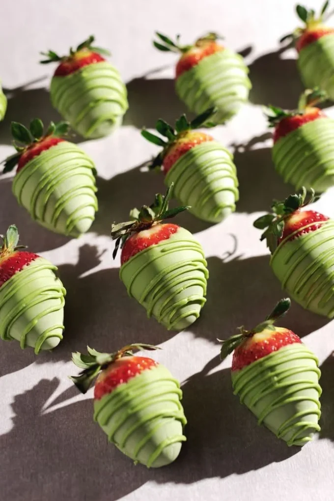 White chocolate matcha-covered strawberries arranged on a plate