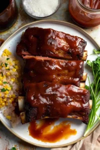 Deliciously grilled barbecue beef ribs served on a wooden platter.