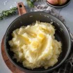 Bowl of classic mashed potatoes with butter and herbs