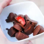 Chocolate-dipped frozen strawberry bites on a plate