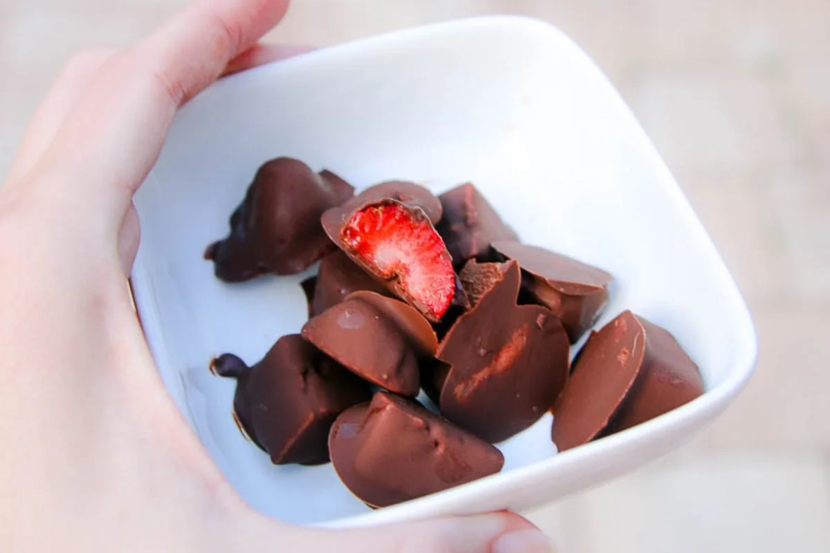 Chocolate-dipped frozen strawberry bites on a plate