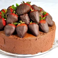 Decadent chocolate fudge cake with truffle-dipped strawberries on top.