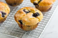 Freshly baked blueberry muffins on a cooling rack