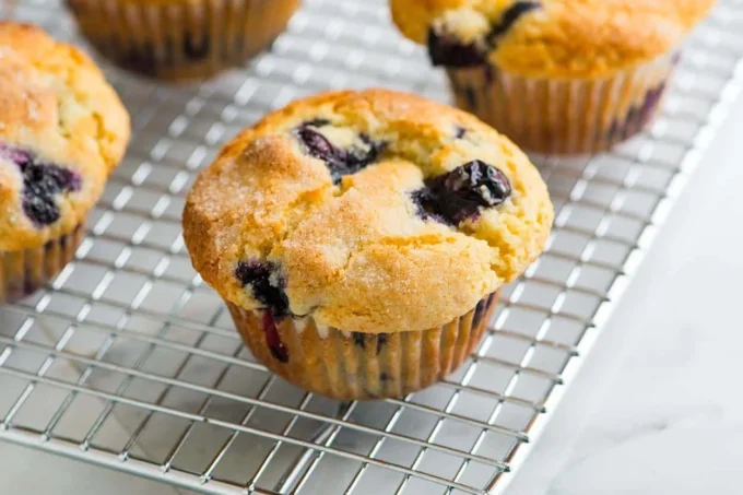 Freshly baked blueberry muffins on a cooling rack